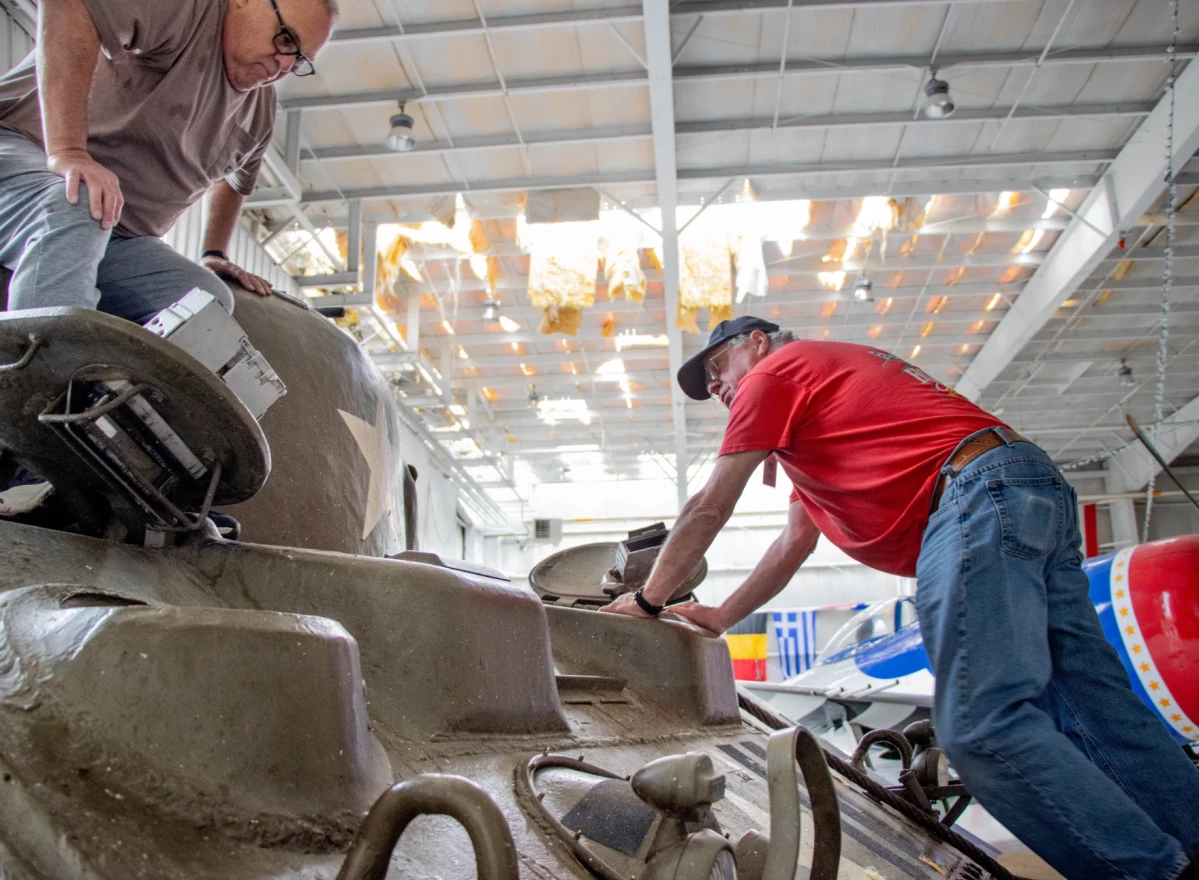 Bruce Green (left) and Richard Hockensmith finish closing up “Rosie's Revenge” — a 1943 Sherman Tank, to keep water out of the machine on April1.